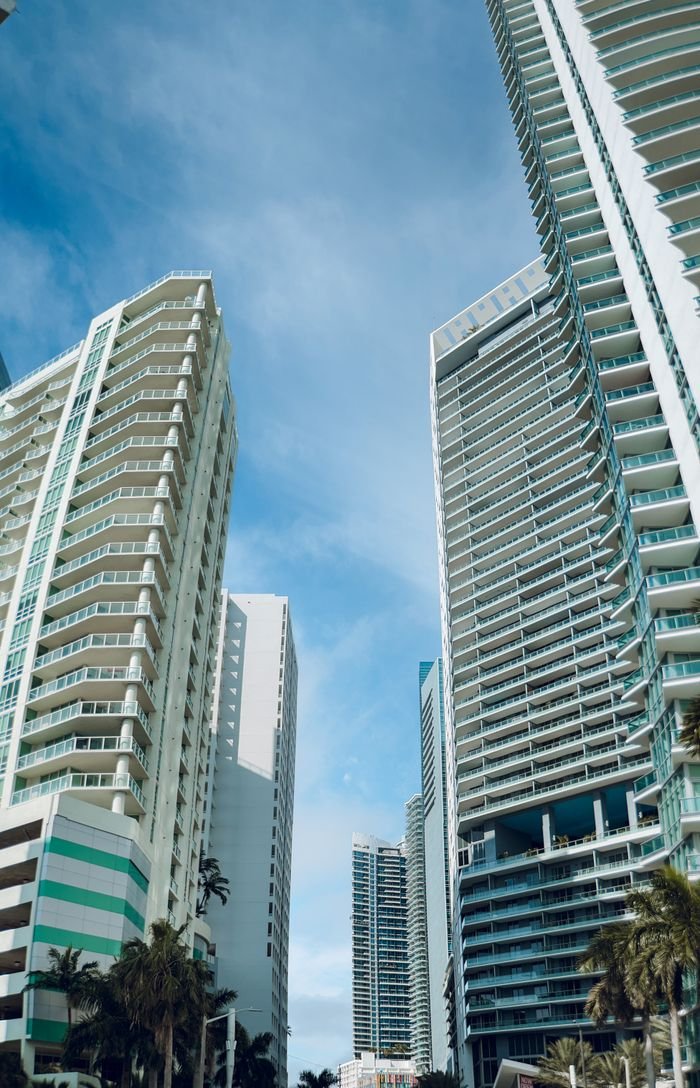 Upward view of tall modern skyscrapers under a clear blue sky, showcasing urban architecture.