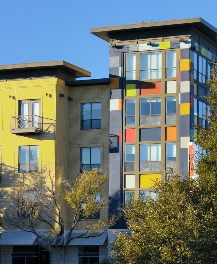 about-05 A vibrant multicolored residential building facade in a cityscape during the day.