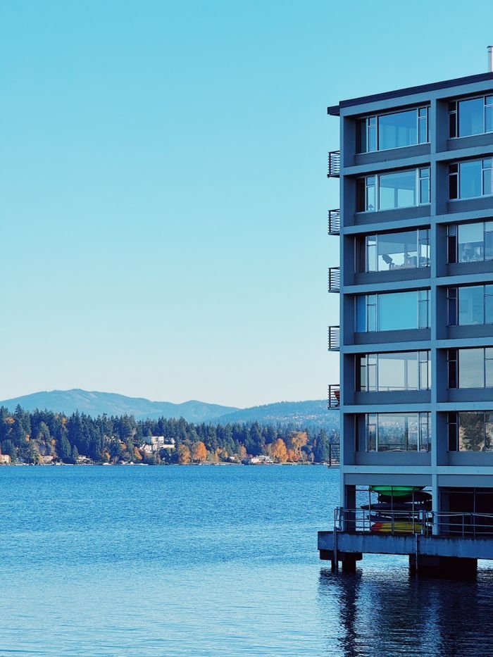 Contemporary building by the serene lake with mountain backdrop, ideal for travel and architecture themes.