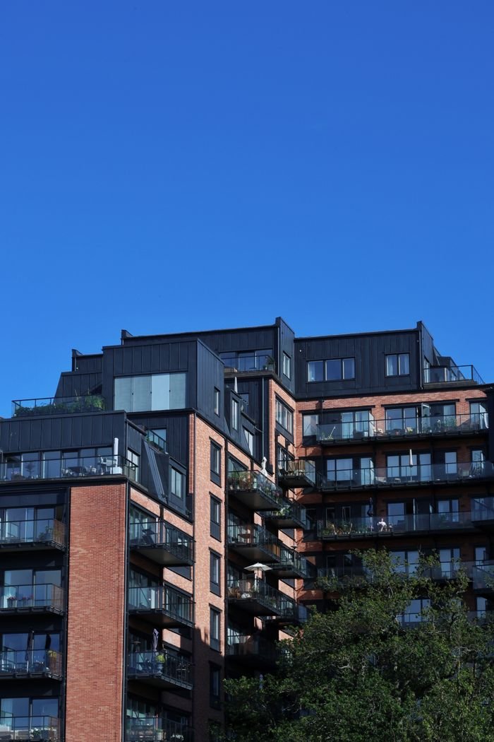 Modern residential building against a clear blue sky in Stockholm, Sweden.